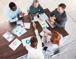 a group of people sitting around a table shaking hands